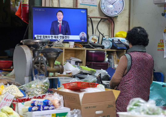 2024년 첫날인 1일 오전 서울 시내 한 전통시장에서 한 상인이 윤석열 대통령의 2024년 신년사 중계방송을 지켜보고 있다. [연합뉴스]